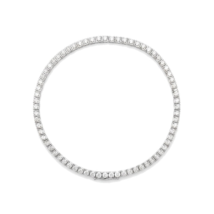 Diamond tennis bracelet in white gold, top view, lying flat. Creation Paul H